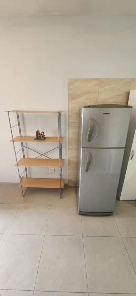 una cocina con refrigerador junto a un mostrador en Andino Apartaments Rental Rivadavia en San Juan