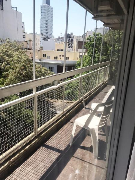 un balcón con 2 bancos blancos en un edificio en Departamento en Palermo dos dormitorios para 5 con balcón en Buenos Aires