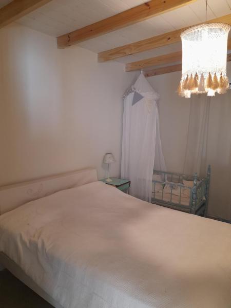 1 dormitorio con cama blanca y lámpara de araña en Los pinares en Santa Clara del Mar