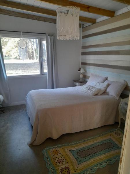 Un dormitorio con una cama grande y una ventana en Los pinares en Santa Clara del Mar