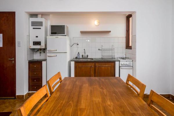 cocina con mesa de madera y refrigerador blanca en Departamento 20 de Febrero 1 en Salta