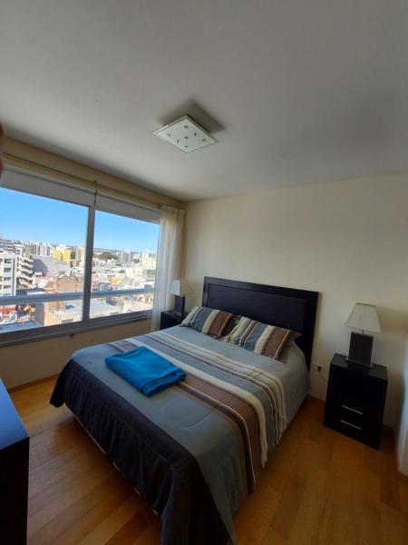 1 dormitorio con cama y ventana grande en Mirador del Golfo Puerto Madryn en Puerto Madryn