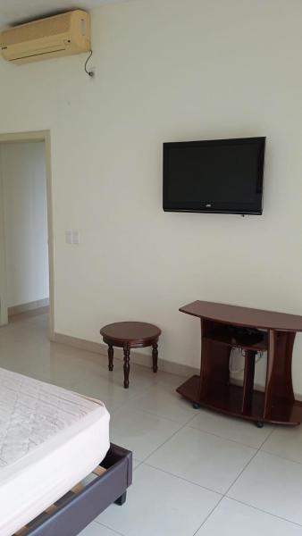 Habitación con cama, mesa y TV de pantalla plana. en Apartamento en Guayaquil, sector Urdesa Central, en Guayaquil
