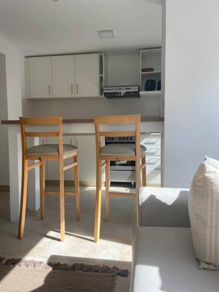una cocina con 2 sillas y una mesa en una habitación en A Luminoso y Practico Monoambiente en Mar del Plata en Mar del Plata