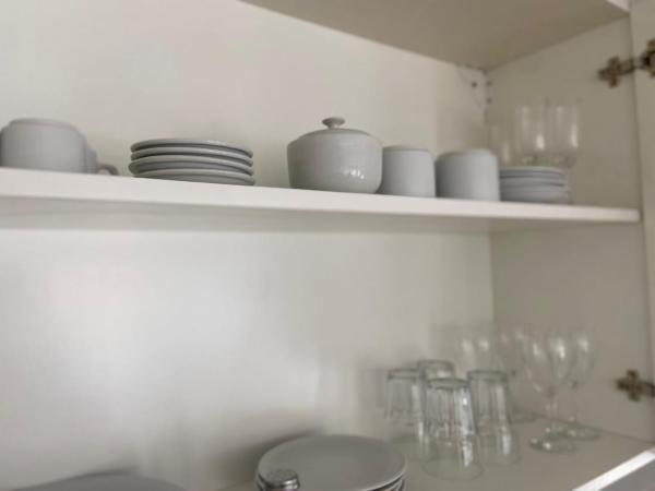 un estante de cocina con platos y vasos. en A Luminoso y Practico Monoambiente en Mar del Plata en Mar del Plata