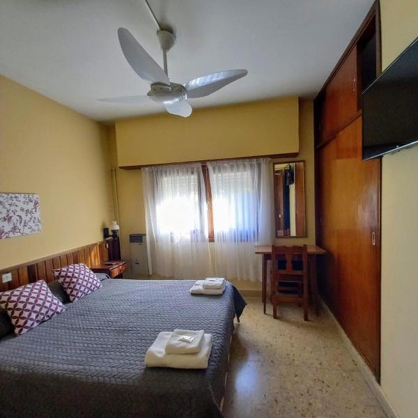 1 dormitorio con 1 cama y ventilador de techo en Hotel Meson en Pinamar