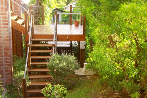 una escalera de madera que conduce a una terraza en un jardín en Hotel Fontanet en Villa Gesell