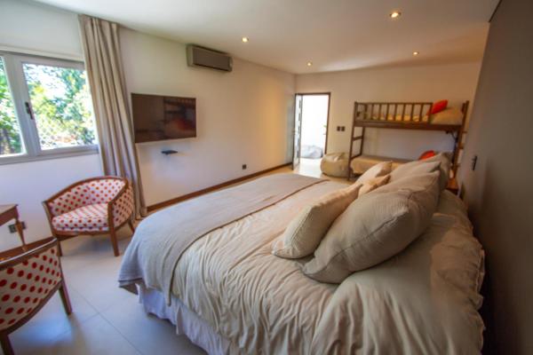 1 dormitorio con 1 cama grande y 1 silla en La Escondida en Mendoza
