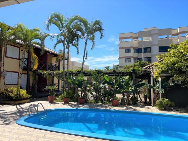 una piscina frente a un edificio con palmeras en Sal De Mariscal 04, en Bombinhas