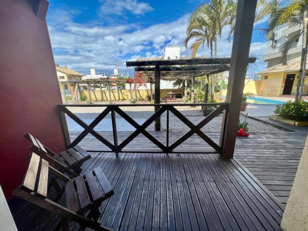 una terraza de madera con un banco y una piscina en Sal De Mariscal 04, en Bombinhas