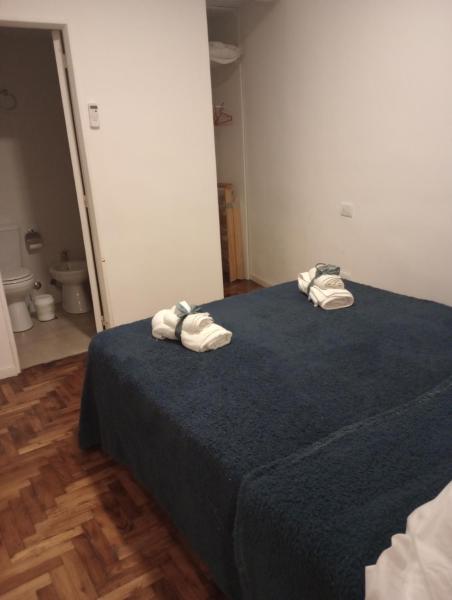 Un dormitorio con una cama azul con toallas. en Botanico 2 ambientes en Buenos Aires