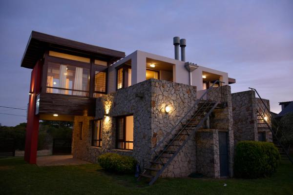 una casa con una escalera frente a ella en Cabañas Cambados en Villa Gesell