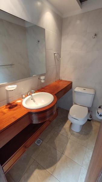 un baño con aseo y aseo y espejo en Cabañas Cambados de Villa Gesell