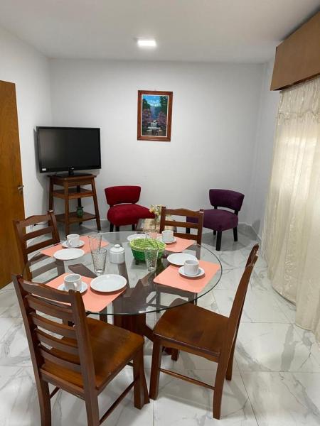 sala de estar con mesa, sillas y TV en WHITE HOUSE en San Salvador de Jujuy