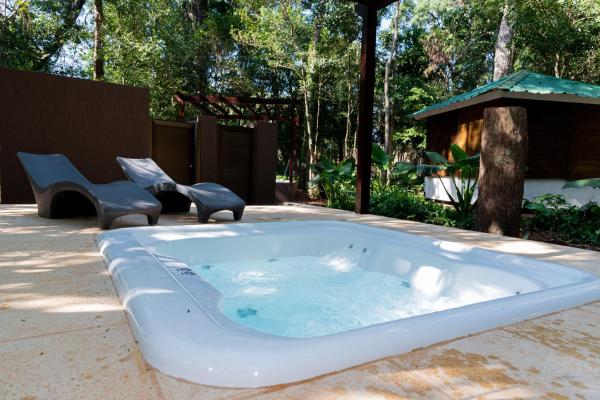 un jacuzzi con dos sillas en un patio en Village Cataratas en Puerto Iguazú