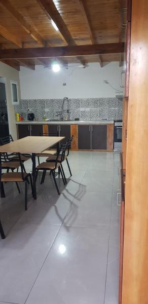 cocina y comedor con mesa y sillas en Casa costa chica en Las Toninas