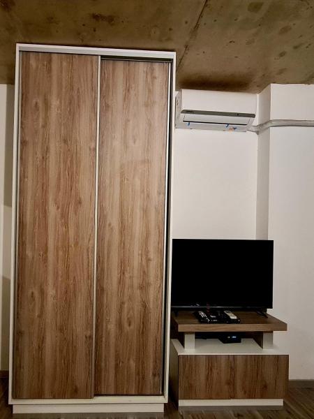 un gran armario de madera en una habitación con TV en Altos Dean Funes en Salta