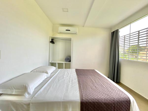 a bedroom with a large bed and a window at Dona Floripa in Florianópolis