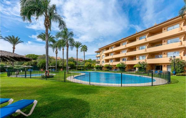 un complejo con piscina con palmeras y un edificio en Stunning apartment in Marbella-Elviria with 2 Bedrooms, WiFi and Outdoor swimming pool, en Marbella