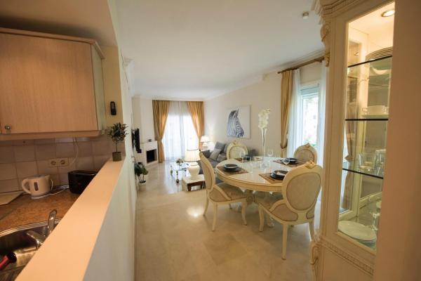 cocina y comedor con mesa y sillas en Spacious flat with pool in Marbella, en Marbella