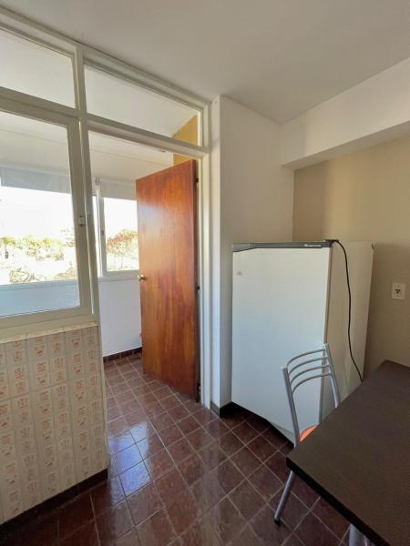 cocina con refrigerador, mesa y ventana en APART CIUDAD MENDOZA en Mendoza