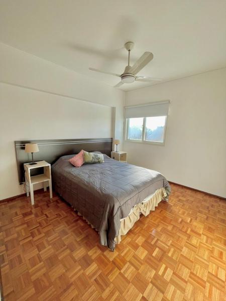 1 dormitorio con 1 cama y suelo de madera en APART CIUDAD MENDOZA en Mendoza