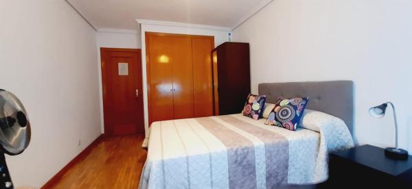 1 dormitorio con 1 cama con manta azul y blanca en Habitación, muy amplia y luminosa, muy cerca del centro a 15 min en el metro en Sol y Gran Via, en Madrid