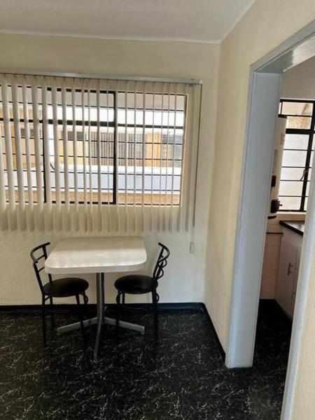 1 mesa y 2 sillas en una habitación con ventana al Departamento ejecutivo céntrico, bien comunicado, en Ciudad de México