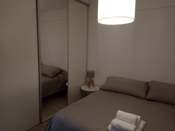 1 dormitorio con espejo y 1 cama con 2 toallas en Cabildo Complete Suite 3 en Buenos Aires