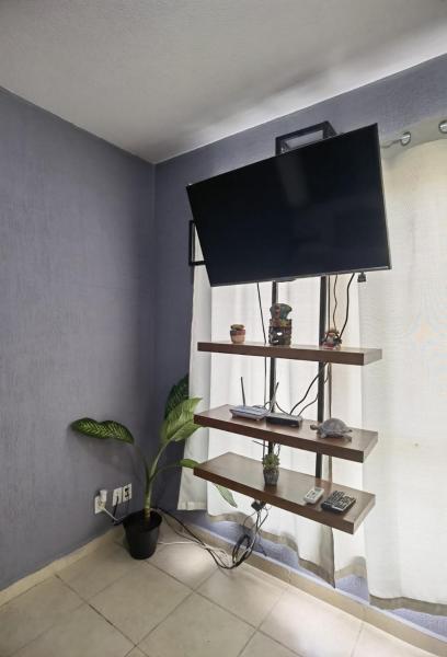 sala de estar con TV y planta en CASA VADO, en Playa del Carmen