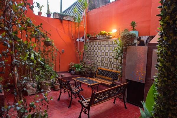 un patio con 2 bancos, una mesa y plantas en Departamento temporario ideal para grupos hasta 15 Personas en Palermo en Buenos Aires