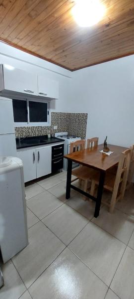 cocina con mesa de madera y techo de madera en Doña beti en Puerto Iguazú