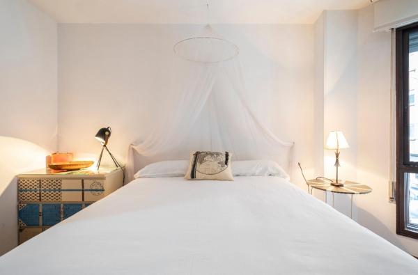 en white bedroom with large white bed and window at Lujoso y amplio piso con 5 habitaciones en Santiago de Compostela