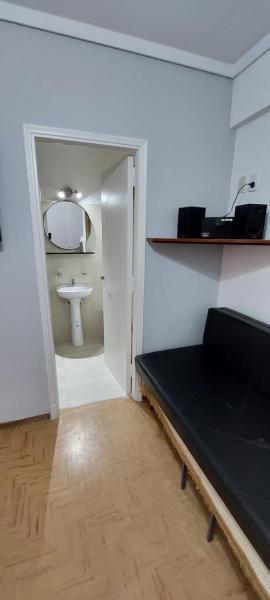 Habitación con cama y baño con lavabo. en Depto mardel cómodo luminoso cerca de todo en Mar del Plata