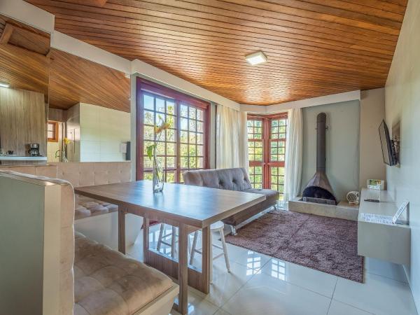 cocina con techo de madera, mesa y sillas en Vista Real 102 - Apartamento à 4 minutos da Rua Coberta de Gramado, en Gramado