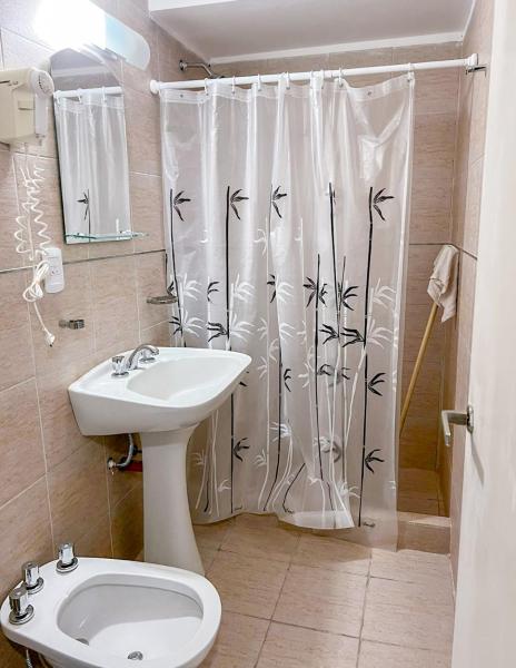 baño con aseo y cortina de ducha en Hotel Tiburones Club en Villa Gesell
