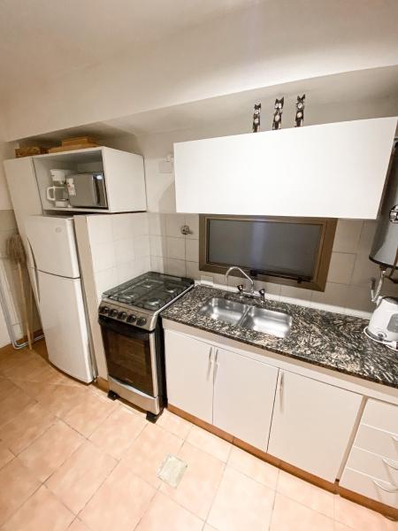 una pequeña cocina con fregadero y refrigerador. en Monoambiente de diseño confortable -Puerto Madryn en Puerto Madryn