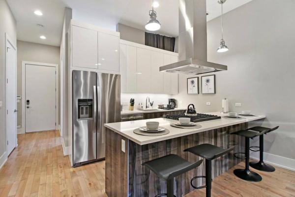 cocina con barra y 2 taburetes en 2BR Well-Equipped Apartment with Laundry and Wi-Fi - Crosby 205, en Chicago