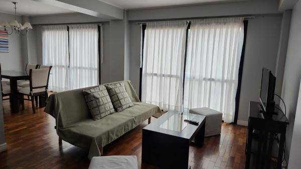 sala de estar con sofá y mesa en Leguizamon Plaza Deluxe en Salta
