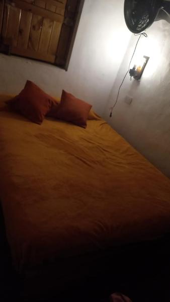 1 dormitorio con 1 cama con luz en la pared en Casa Alpina espaciosa a 2 cuadras del centro de Villa Gesell ya 5 de la playa en Villa Gesell