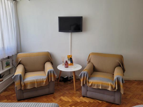 2 sillas y una mesa en una habitación con TV en Alto Santa Fe en Buenos Aires