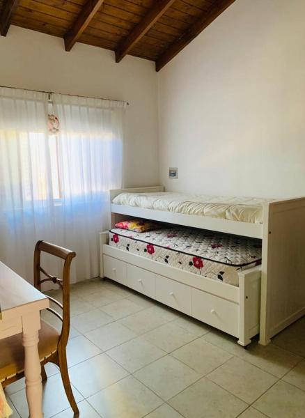 Un dormitorio con una litera blanca con flores. en LOS SAUCES CHASCOMUS en Chascomús