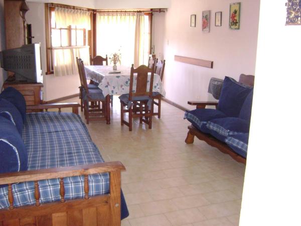 sala de estar con sofá, mesa y sillas en El Ebro en Villa Gesell