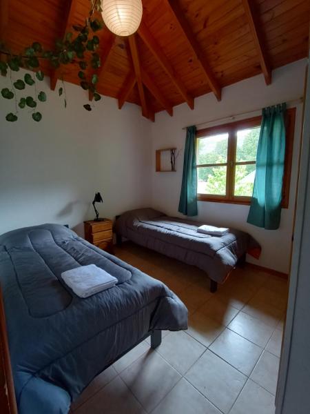 1 dormitorio con 2 camas y ventana en Departamento Orillas del Pocahullo en San Martín de los Andes