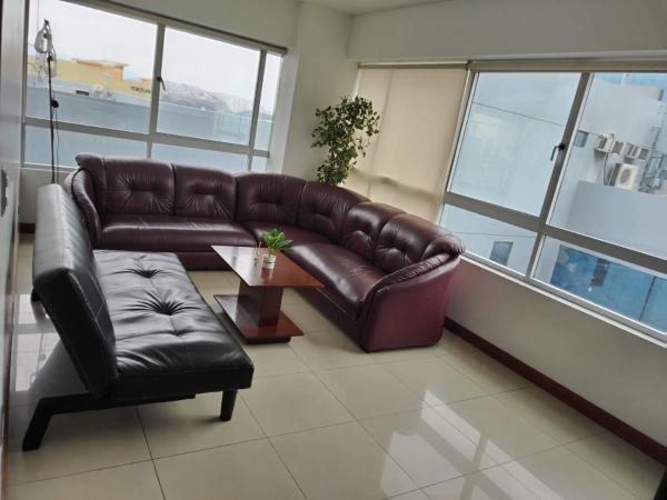 sala de estar con sofá de cuero y mesa en Ecusuites TorreSol I Parking, en Guayaquil