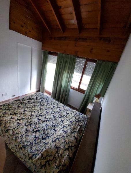 1 dormitorio con 1 cama en una habitación con ventanas en Complejo Nuevo Golf en Pinamar