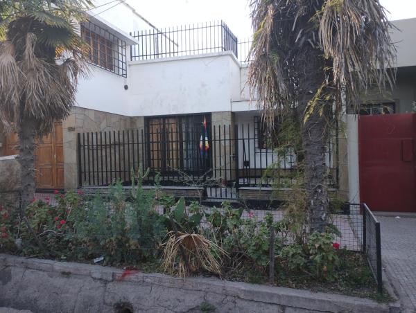 una casa con una valla y una palmera en La posada de Doña Teresa en Mendoza