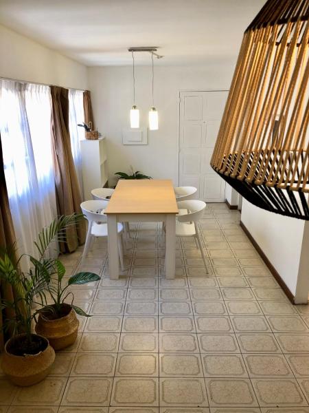 comedor con mesa blanca y sillas en El cielo apartamento en Mendoza