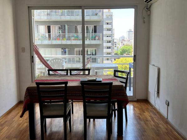 comedor con mesa y sillas y ventana grande en Departamento entero 2 ambientes en Buenos Aires