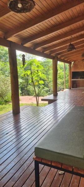 una terraza de madera con una cama encima en OMA CHILL HOUSE IGUAZU en Puerto Iguazú